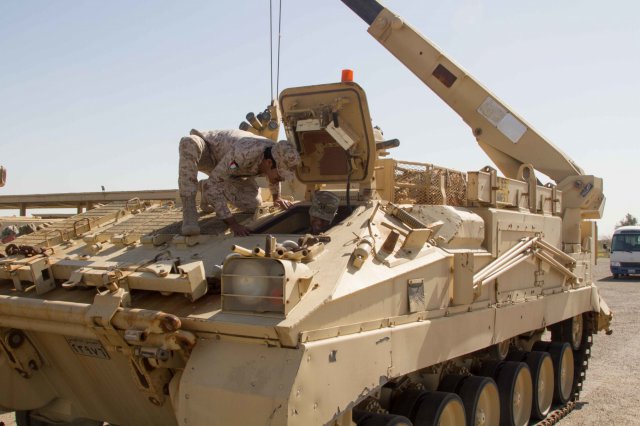 A Kuwaiti army officer with the 35th Armored Brigade tells U.S. Army Central's Capt. David Smith about the controls of a recovery vehicle during a leader professional development seminar at the headquarters for 35th Armored Brigade. The day's events focused on the role the 35th Armored Brigade played at the Battle of the Bridges, a large battle at the beginning of Saddam Hussein's invasion of Kuwait 25 years ago. 