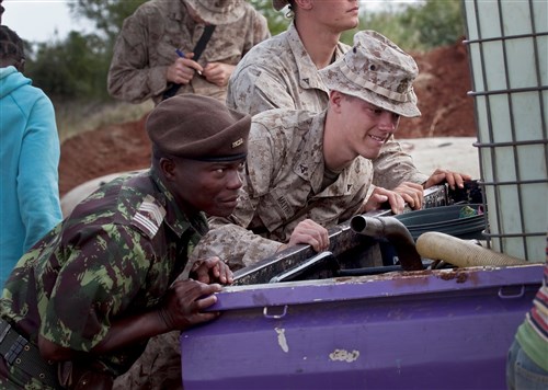 MOAMBA, Mozambique - Twenty-year-old Lance Corporal Nathan Matthai, a Marine with 4th Logistics Support Battalion, along with soldiers from the Armed Forces for the Defense of Mozambique (FADM), help push-start a pick-up truck July 30, 2010. The truck had been weighed down by a drum of freshly purified river water. Marines with 6th Engineer Support Battalion are working to purify a local water source for civilian use and mission support as part of exercise SHARED ACCORD 2010. The 10-day exercise, which runs August 3-13, will include staff training, small unit tactical training, and humanitarian civic-assistance programs to include medical services, dental services, and engineering projects. (Photo by Corporal Scott Schmidt, U.S. Marine Forces Africa)