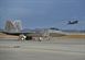 An F-22 Raptor from Tyndall Air Force Base, Fla. sits on the flightline while a Raptor launches from the Tyndall runway Dec. 10 during Checkered Flag 16-1. During this large-force exercise, fourth and fifth generation aircraft integrated their capabilities to provide better situational awareness for the Air Force fleet. (U.S. Air Force photo by Senior Airman Sergio A. Gamboa/Released)