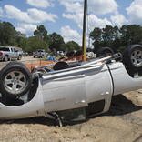 <p>Car flipped over by the 2016 severe flooding in Louisiana remains on the side of the road in Denham Springs. (Photo by J.T. Blatty/FEMA)</p>