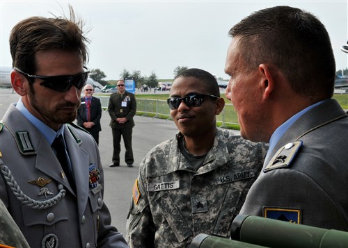 BERLIN - Army Sgt. Antonio Gattis, Charlie Company 1-214 Aviation Regiment flight medic, Landstuhl, Germany, reunites with German soldiers here Sept. 11, 2012 at the Berlin Air Show, commonly known as ILA 2012. Four German soldiers visited Gattis at the U.S. military "corral."