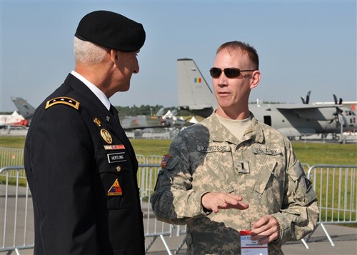 BERLIN - Army Lt. Gen. Mark Hertling, U.S. Army Europe and Seventh Army commander, speaks with Chief Warrant Officer 3 Jason Lacrose, Joint Multinational Readiness Center Falcons instructor pilot, Hohenfels, Germany, on the opening day of the Berlin Air Show, commonly known as ILA 2012, here Sept 11. ILA 2012 is an international event hosted by Germany and more than 50 U.S. military personnel from bases in Europe and the United States are here to support the various U.S. military aircraft and equipment on display. The U.S. aircraft featured at ILA 2012 are the UH-60 Black Hawk, UH-72A Lakota, F-16C Fighting Falcon, C-17 Globemaster III, and C-130 Hercules.