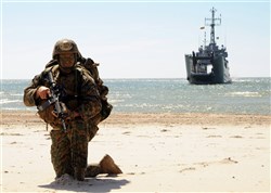 PALANGA, Lithuania – U.S. Marine Sgt. Christopher Judy holds position on a beach with the Polish vessel OPR Krakow in the background during a Baltic Operations (BALTOPS) 2012 amphibious operation exercise, June 11. This is the 40th iteration of BALTOPS, a maritime exercise intended to improve interoperability with partner nations by conducting realistic training at sea. 