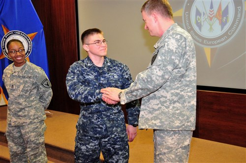 U.S. European Command Deputy Commander Lt. Gen. William Garrett III presents a coin to Petty Officer 3rd Class, awards NCO, for outstanding performance. 