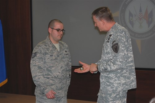 U.S. European Command Deputy Commander Lt. Gen. William Garrett III presents a coin to Tech. Sgt. John Ruiz, Air Cell, for outstanding perfomance.