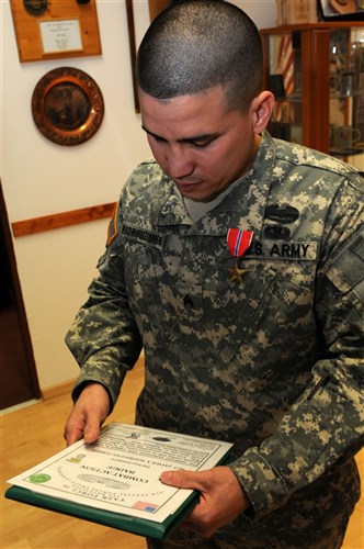 Sgt. Javier Rodriguez-Torres, left, a food service specialist assigned to Headquarters Support Company, 1st Battalion, 10th Special Forces Group (Airborne), reads his certificate awarding him the Combat Action Badge following his award ceremony in which he was presented the Bronze Star Medal and the Combat Action Badge for his courageous actions on the battlefield while actively engaging the enemy during his tour in Afghanistan serving with Special Operations Task Unit 0112, Task Force 10. (U.S. Army photo by Master Sgt. Donald Sparks approved for public release by MAJ James Gregory, SOCEUR PAO)