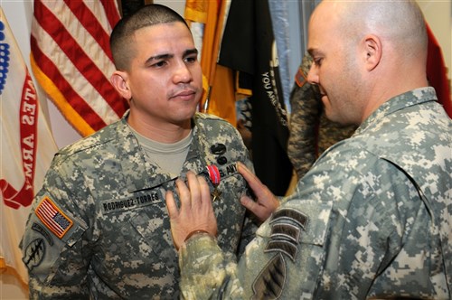 Sgt. Javier Rodriguez-Torres, left, a food service specialist assigned to Headquarters Support Company, 1st Battalion, 10th Special Forces Group (Airborne), is presented the Combat Action Badge by Lt. Col. Isaac Peltier, commander, 1-10 SFG(A), for his courageous actions on the battlefield while actively engaging the enemy during his tour in Afghanistan serving with Special Operations Task Unit 0112, Task Force 10. (U.S. Army photo by Master Sgt. Donald Sparks approved for public release by MAJ James Gregory, SOCEUR PAO)