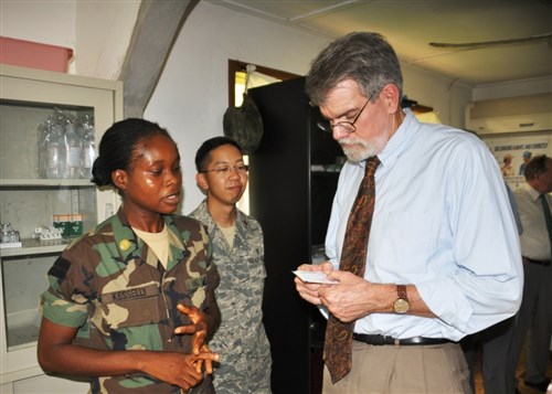 MONROVIA, Liberia - Officer Candidate Yonger Kesselly (left), a nurse in the Armed Forces of Liberia, explains how a malaria rapid detection test works to Ambassador J. Anthony Holmes, deputy to the commander for civil-military activities, U.S. Africa Command (AFRICOM), October 25, 2010. Behind Kesselly is U.S. Air Force Dr. (Major) Alexander Bingcang, a U.S. military medical mentor to the AFL. Kesselly will become an AFL medical officer after she is promoted to second lieutenant. Holmes is in Monrovia on a three-day visit to gain insight into the security assistance activities AFRICOM conducts with the Armed Forces of Liberia (AFL).  Visiting Liberia for the first time, he met with AFL soldiers and the U.S. military mentors who work to advise the AFL. AFRICOM began a five-year mentoring program in January 2010, led by its Marine component, Marine Forces Africa. (US Africa Command photo by Kenneth Fidler)