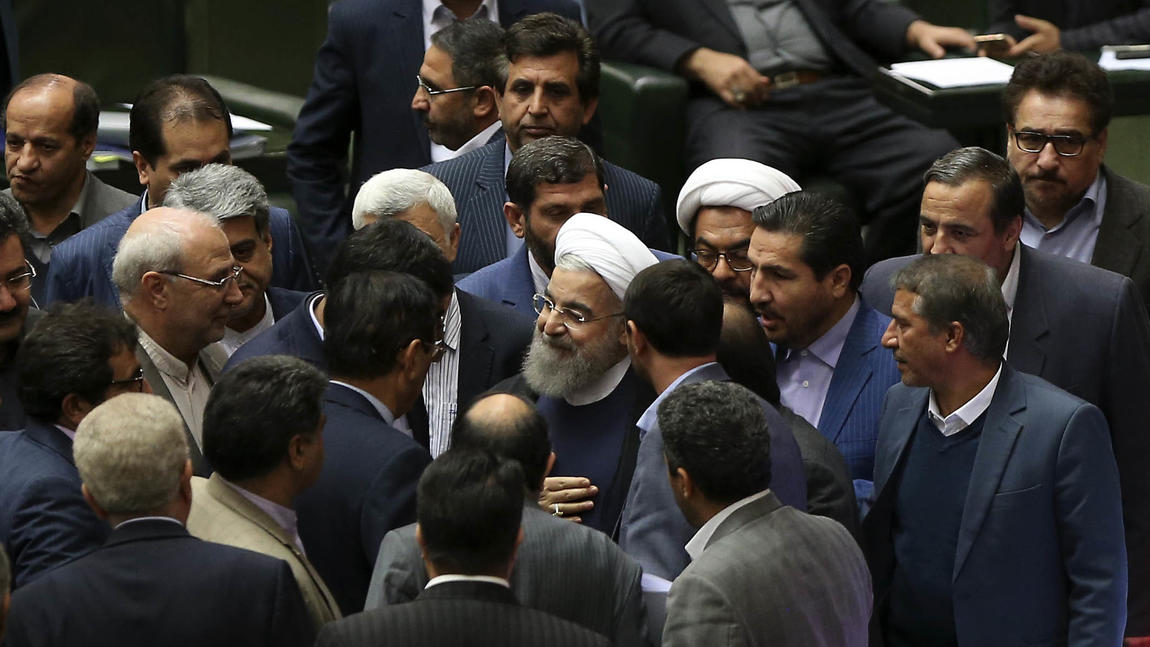 Iranian President Hassan Rouhani is surrounded by lawmakers in parliament Sunday. (Vahid Salemi / Associated Press)