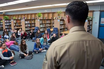 'Lance Cpl. Dave Flores, combat correspondent, Headquarters Battalion, answers students’ questions during a visit to La Contenta Middle School in Yucca Valley, Calif., Nov. 30, 2016. Don Henry, a teacher at the middle school, coordinates the event annually in an effort to teach his students about the military while giving them a chance to show their appreciation in the form of letters. (Official Marine Corps photo by Cpl. Medina Ayala-Lo/Released)'