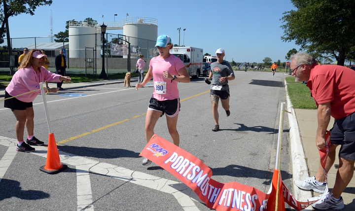 Navy Lt. Cmdr. Elizabeth Raphael, assigned to Public Health Services, center, is the first female to cross the finish line at the Pink Ribbon 5K Run at the Naval Medical Center Portsmouth fitness center. October, women are reminded to put themselves first and make time for their health. Making your health a priority helps you stay in optimum shape and keeps illnesses and disease at bay. (U.S. Navy photo by Mass Communication Specialist 2nd Class Nikki Smith) 