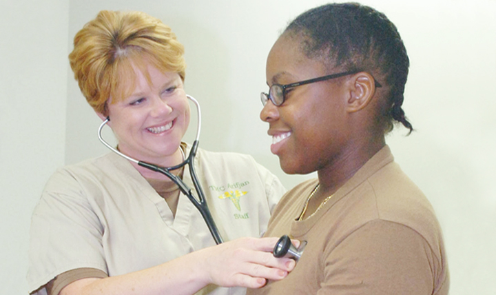 At Camp Arifjan, Kuwait, in 2006, Navy Lt. Cmdr. Carolyn Currie, a women's nurse health practitioner at the Expeditionary Medical Facility- Kuwait, discusses health issues with Hospital Corpsman LaQunia Williamson. As the number of women in the service has increased, so has the need for adequate access to women's health care during deployments.