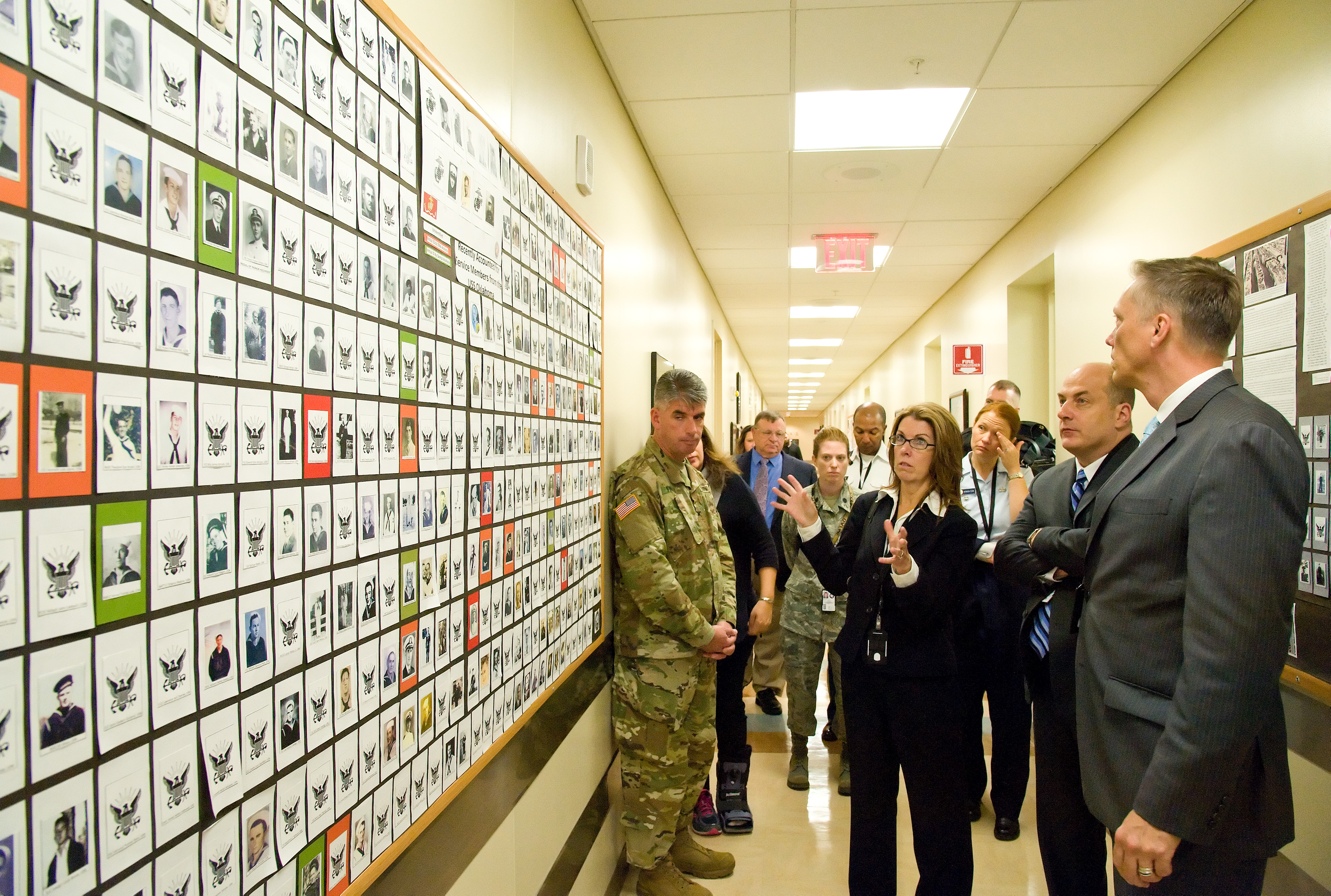 Todd Weiler, Assistant Secretary of Defense for Manpower and Reserve Affairs, and Ronald Keohane, Deputy Assistant Secretary of Defense for Military Community and Family Policy; listen to Deborah Skillman, Director, Casualty, Mortuary Affairs and Military Funeral Honors from the Office of the Deputy Assistant Secretary of Defense for Military Community and Family Policy, explain the display board of confirmed USS Oklahoma remains identified by the Armed Forces DNA Identification Laboratory Nov. 4, 2016, at Armed Forces Medical Examiner System on Dover Air Force Base, Del. Weiler and Keohane received briefings and met with personnel at the Air Force Mortuary Affairs Operations, AFMES and the Joint Personal Effects Depot. (U.S. Air Force photo by Roland Balik)