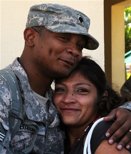 NAPLES, Italy (August 12, 2011)  - Spc. Cezarian Bass, a Soldier from the 2nd NATO Signal Battalion, Deployable Communications Module, Alpha Company (DCM-A), attached to Joint Forces Command (JFC) Naples, hugs his wife after returning home from a 6-month deployment to Afghanistan.    DCM-A is part of a regular rotation of companies stationed at JFC, tasked with providing communications for Command Joint 6 in Kabul, Afghanistan, as well as all NATO communications for headquarters in support of joint operations in Afghanistan. (U.S. Navy photo by Mass Communication Specialist 3rd Class Caitlin Conroy/Released)