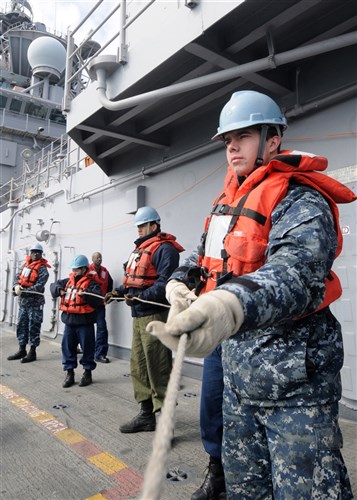 MEDITERRANEAN SEA (Mar. 10, 2011) Seaman Apprentice David Hanley hauls in the phone and distance line during a replenishment-at-sea between USS Kearsarge (LHD 3) and USNS Kanawha (T-AO 196). Kearsarge is the command ship of Kearsarge Amphibious Ready Group, supporting maritime security operations and theater security cooperation efforts in the U.S. 6th Fleet area of responsibility. (U.S. Navy Photo By Mass Communication Specialist 2nd Class Stevie Tate)