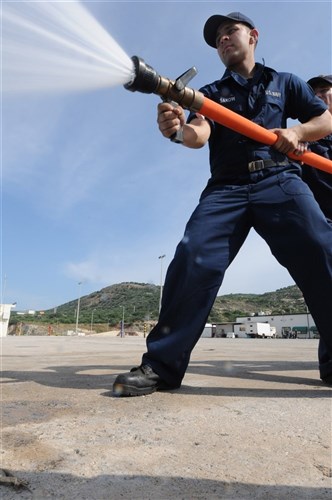 SOUDA BAY, Crete (June 2, 2011) -- U.S. Navy Fireman Daniel Saknow demonstrates fire hose handling during a damage control exercise at Marathi Pier in Souda Bay, Greece, June 2, as a part of Phoenix Express 2011 (PE-11).  A three-week evolution divided into two phases of training, PE-11 is designed to enhance regional maritime partnerships among the 13 participating nations in their efforts to deter illicit trafficking at sea.  