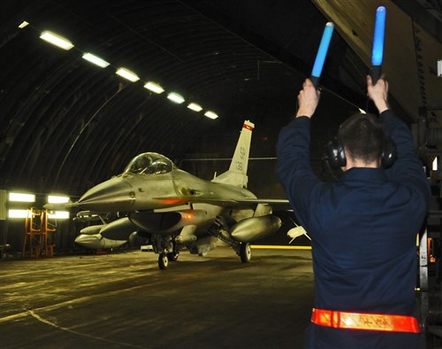 SPANGDAHLEM AIR BASE, Germany (March 18, 2011) - A crew chief from the 52nd Aircraft Maintenance Squadron marshals an F-16 Fighting Falcon out of a hardened aircraft shelter here in support of Joint Task Force Odyssey Dawn (JTF OD). JTF OD is the U.S. Africa Command task force established to provide operational and tactical command and control of U.S. military forces supporting the international response to the unrest in Libya and enforcement of United Nations Security Council Resolution (UNSCR) 1973.  UNSCR 1973 authorizes "all necessary measuress" to protect civilians in Libya under threat of attack by Qadhafi regime forces.  JTF Odyssey Dawn is commanded by U.S. Navy Admiral Samuel J. Locklear, III. (U.S. Air Force photo by Staff Sgt. Benjamin Wilson/Released)