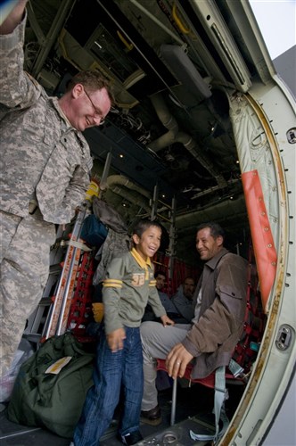 DJERBA ZARIS, TUNISIA (March 13, 2011) -- Spc. Neil Stanfield shows an Egyptian boy around the U.S. Air Force C-130J aircraft that will fly them from Djerba Zarzis Airport in Tunisia to Cairo, Egypt. This Egyptian boy is among tens of thousands who have fled conflict in Libya to Tunisia, where a humanitarian crisis is unfolding. This C-130J, flown by the 37th Airlift Squadron from Ramstein Air Base, Germany, is part of a contingent of aircraft from the 37th and the 26th U.S. Marine Expeditionary Unit that are transporting the evacuees home. The airlift is part of a broader U.S. government effort led by the Department of State to assist with the crisis. (U.S. Army photo by Staff Sgt. Brendan Stephens/Released)