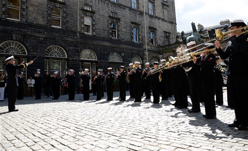 
U.S. Naval Forces Europe and Africa Band director Lt. David Latour, left, leads the band as its conductor, as they play "Anchors Aweigh" for the Lord Lieutenant and Lord Provost of the City of Edinburgh, the Right Honorable David Wilson, outside the city chambers building, July 30. The CNE band is in Edinburgh to perform in the Royal Edinburgh Military Tattoo with musicians, dancers and bagpipers from around the world coming to perform in the month long show. 
