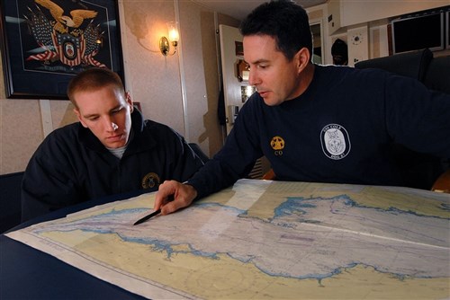 ATLANTIC OCEAN &mdash; Ensign Francis Dore, the navigator aboard the guided-missile destroyer USS Cole (DDG 67), reviews navigational charts with commanding officer Cmdr. Edward Devinney. Cole recently completed Exercise Joint Warrior 09-2 and is continuing routine operations in the U.S. 6th Fleet area of responsibility. (U.S. Navy photo by Mass Communication Specialist 3rd Class Matthew Bookwalter)