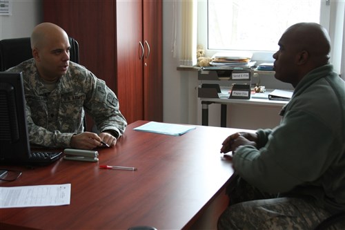 SCHWEINFURT, Germany &mdash; Army Spc. Jamaleldine (left), site coordinator at the Schweinfurt Tax Office, assists a soldier, Feb. 1. Jamaleldine, a wounded warrior, still contributes to the Army mission and will attend Officer Candidate School in Ft. Benning, Ga. (Joint Multinational Training Command Emily Athens photo)