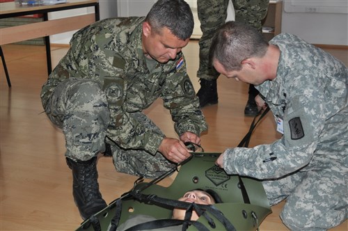 Demonstrating how to use the Skedco Litter is Sgt. 1st Class Boris Ledencan, Croatian Army (left) and Sgt. Kevin Perry 557th Area Support Medical Company, 421st Multifunctional Medical Battalion (right), in Croatia, June 20. This training was part of Immediate Response 2012, a multinational training exercise of over 700 personnel from seven countries.  