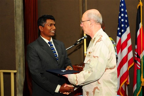 MOMBASA, Kenya - Vice Admiral Robert T. Moeller, U.S. Africa Command's deputy to the commander for military operations, presents Outam Kumar Guness with a graduation certificate during the first Maritime Center of Excellence (MCE) graduation held at the Bandari College in Mombasa on July 10, 2009. Guness is the deputy assistant superintendent of police for Mauritius and was one of seventeen students from eight African countries who graduated the course. MCE is sponsored by Combined Joint Task Force-Horn of Africa and provides operational level training that builds maritime safety and security capacity in order to promote a stable and secure Africa. (Photo by Petty Officer 1st Class Jonathan Kulp, CJTF-HOA) 