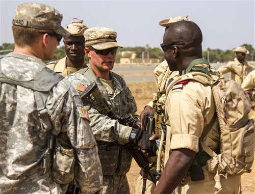 A Soldier from Co. A 1st Bn., 28 Inf. Regt. 4th IBCT, 1st Inf. Div. shakes hands with a Soldier from Burkina Faso after receiving instructions on personnel searching and traffic control point procedures during Exercise Western Accord 14, June 17. Exercise Western Accord is a partnership exercise between the United States and ECOWAS, which is designed to increase interoperability between military forces and ensure the common ability to conduct peace operations throughout Western Africa.