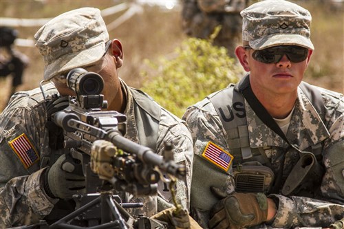 Pfc. Marcelo Alvarez (left) and Pfc Zachary Albin (right) from Co. A 1st Bn., 28 Inf. Regt. 4th IBCT, 1st Inf. Div. show Soldiers from Burkina Faso how to secure a traffic control point with an M240B machine gun during Exercise Western Accord 14, June 17. Exercise Western Accord is a partnership exercise between the United States and ECOWAS, which is designed to increase interoperability between military forces and ensure the common ability to conduct peace operations throughout Western Africa.