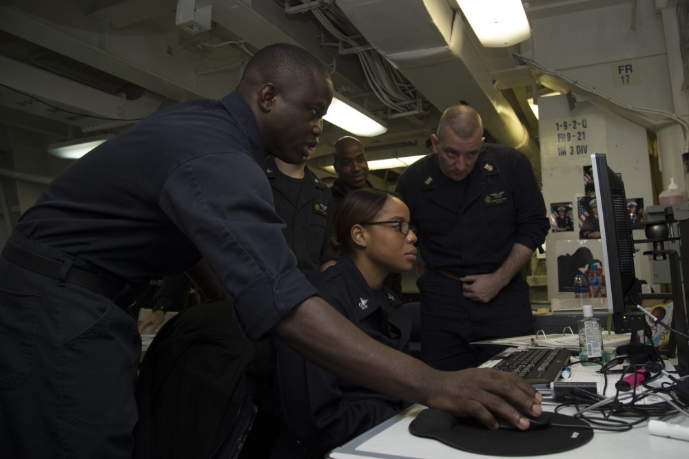 ARABIAN GULF (Nov. 18, 2016) Petty Officer 2nd Class Olatunbosun Adebanjo, left, teaches Sailors participating in the Green Belt course in the continuous process improvement classroom aboard the aircraft carrier USS Dwight D. Eisenhower (CVN 69) (Ike). Adebanjo works as a logistics specialist aboard Ike. Ike and its Carrier Strike Group are deployed in support of Operation Inherent Resolve, maritime security operations and theater security cooperation efforts in the U.S. 5th Fleet area of operations. U.S. Navy photo by Petty Officer 3rd Class Nathan T. Beard.