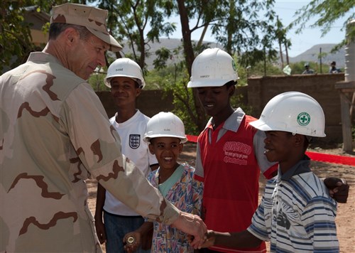 U.S. Navy Rear Admiral Michael Franken, Combined Joint Task Force - Horn of Africa commander, presents command coins to local students for helping U.S. Navy Naval Mobile Construction Battalion Three Seabees during the construction of their new school building and latrines at the Gende Gerada Primary School in Dire Dawa, Ethiopia, May 22, 2012. The students, from left to right, are Abdurehim Nasir, Amir Abdi, Ramzii Ahamed and Anwar Tayir. Seabees from CJTF-HOA were the last of four NMCB teams to work on the 2-year project, which was dedicated at a ceremony on May 22. (Combined Joint Task Force-Horn of Africa photo by Technical Sergeant Ryan Labadens)