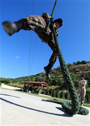 SOUDA BAY, Crete - Moroccan Seaman Elmire Hafib practices fast rope insertion, May 16, under the supervision of U.S. Marine Corps Private 1st Class Joshua Aiken, from the 1st Fleet Anti-terrorism Security Team, at the NATO Maritime Interdiction Operational Training Center during Phoenix Express 2012 (PE12). PE12 is a multinational maritime exercise between Southern European, North African and U.S. Naval forces intended to improve cooperation among participating nations and help increase safety and security in the Mediterranean Sea. (U.S. Navy photo by Petty Officer 1st Class Brian A. Goyak)