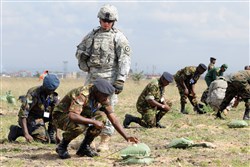 NAIROBI, Kenya - U.S. Army Sergeant Jerry Kastein observes Kenyan army Corporal Samson Kiriungi set up a small C-4 charge for detonation during the final portion of a week-long counter-improvised-explosive-device course taught by the Kenyan Army and assisted by members of the U.S. Army and a team from Africa Contingency Operations Training & Assistance.  The demolition charges were completely rigged by the students, and the successful deployment of the explosives instilled a sense of confidence in the skills they acquired during the course. (AFRICOM photo by Staff Sgt. Austin M. May)