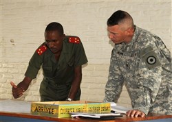 Burundi - Burundian National Defense Force Captain Claver Nahimana goes over the morning briefing with U.S. Army Lieutenant Colonel Gregory Mittman, 2nd Combined Arms Battalion, 137th Infantry commander, during a Command Post Exercise in Burundi. The CPX allowed the BNDF battalion to work as a command element before an upcoming deployment. (U.S. Air Force photo by Staff Sergeant Heather Stanton)