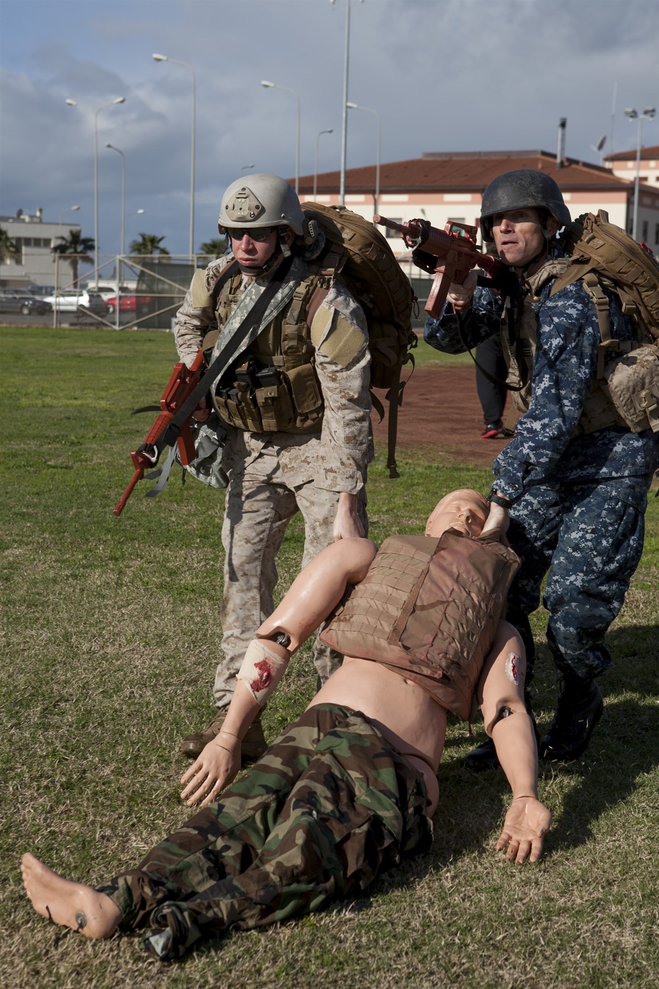 Sergeant Balec Nelson, a Special-Purpose Marine Air-Ground Task Force Africa 13 radio operator from Kailua, Hawaii, and Lieutenant Commander  Jonathan McComb, Naval Criminal Investigative Service, drag a simulated casualty to safety during the final exam of the Tactical Combat Casualty Care course here, March 14, 2013. The TCCC course teaches basic first-responder skills and helps service members prioritize casualty care in combat situations to maximize safety and effective care. Special-Purpose MAGTF Africa strengthens US Marine Corps Forces Africa and US Africa Command's ability to assist partner nations in addressing their security challenges. The approximately 150 Marines and sailors conduct security force assistance, military-to-military engagements and are trained to provide support to crisis response. (Photo by Corporal Timothy Norris)