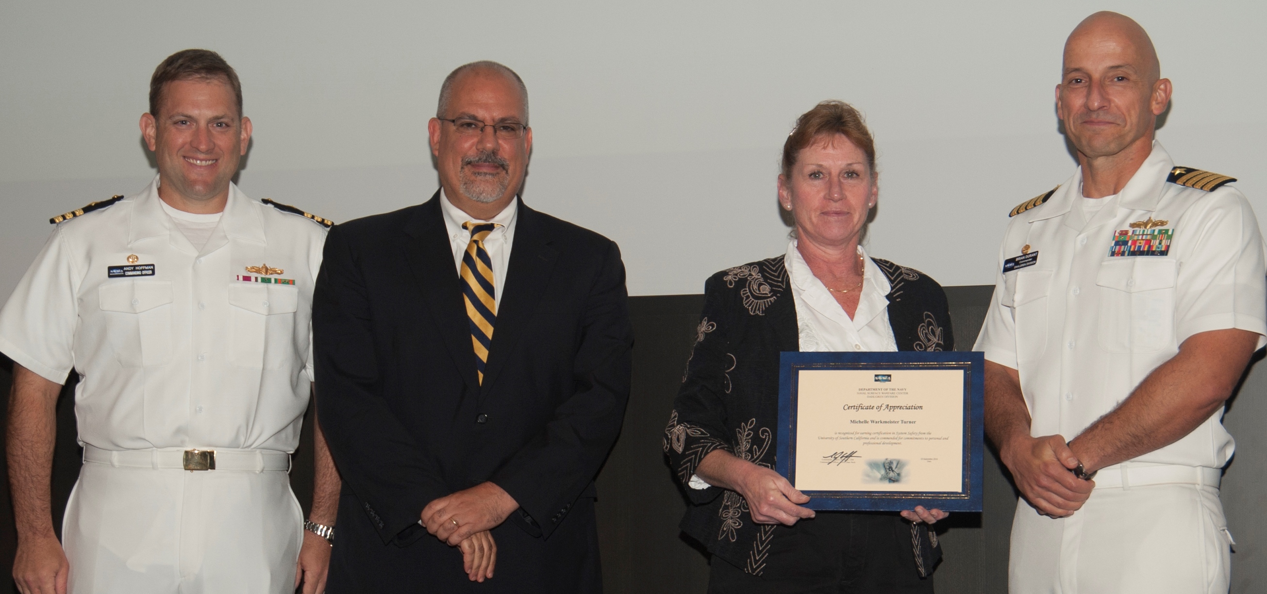 DAHLGREN, Va. - Michelle Turner receives her certificate of appreciation from Naval Surface Warfare Center Dahlgren Division (NSWCDD) Technical Director John Fiore, NSWCDD Commanding Officer Capt. Brian Durant, right, and Combat Direction Systems Activity Dam Neck Commanding Officer Cmdr. Andrew Hoffman at the 2016 NSWCDD academic awards ceremony. Turner was recognized for completing her system safety certification from the University of Southern California, and commended for her commitment to personal and professional development. U.S. Navy photo by George Smith.