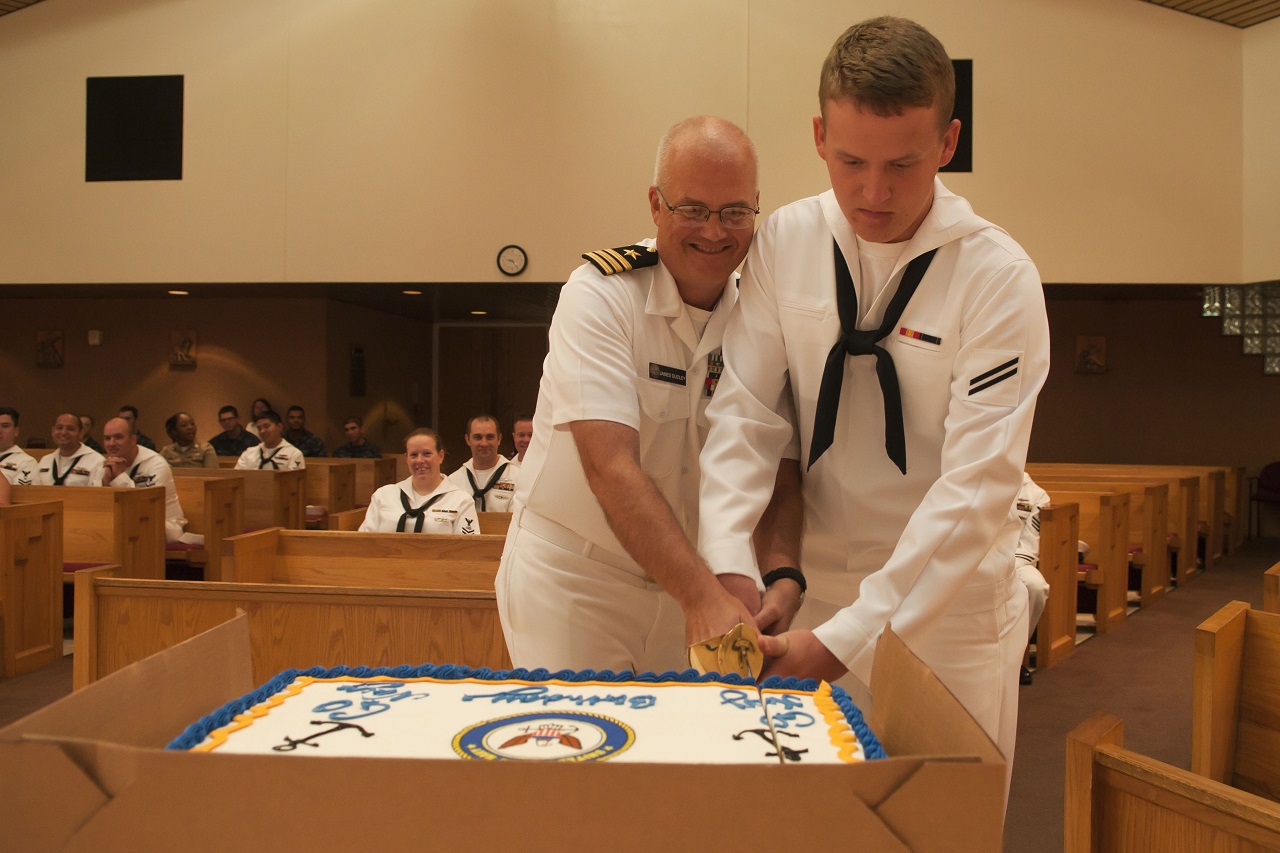 PENSACOLA, Fla. (Oct. 13, 2016) Cmdr. James Dudley (left) and Seaman Jacob Lodes, the oldest and youngest Sailors present during a Navy birthday celebration, use a cutlass to cut the cake at Naval Air Station Pensacola Corry Station's chapel. The theme of the 2016 birthday observance was "America's Sailor. For 241 Years: Tough, Bold and Ready."  U.S. Navy photo by Petty Officer 3rd Class Taylor L. Jackson/Released 