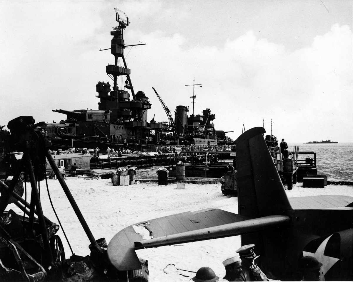 Alongside the Sand Island pier, Midway, disembarking Marine reinforcements, 25 June 1942. Aircraft in the foreground, with damaged tail, is a TBF-1 Avenger (Bureau # 00380), the only survivor of six Torpedo Squadron Eight (VT-8) TBFs that attacked the Japanese fleet on 4 June 1942. Ship in the right distance is probably USS Ballard (AVD-10). Official U.S. Navy Photograph, now in the collections of the U.S. National Archives. 