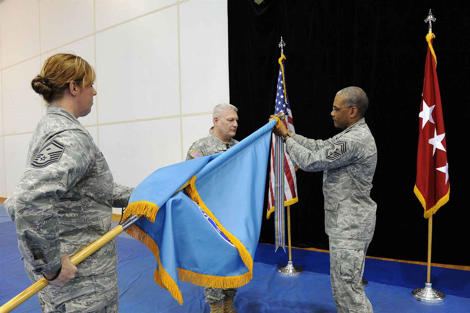 STUTTGART, Germany - General Carter Ham, Commander of U.S. Africa Command and Chief Master Sergeant Jack Johnson Jr., U.S. Africa Command's senior enlisted leader, attach the first streamer for USAFRICOM colors, March 9, 2012. The Command was awarded the Joint Meritorious Unit Award streamer for their response to the conflict in Libya between March 19 and March 30, 2011. During this time, the command coordinated humanitarian and military operations to maintain stability in the region, established a no-fly zone over Libya, and enforced an arms embargo at sea. (U.S. AFRICOM photo by Angeline Hoffmann)