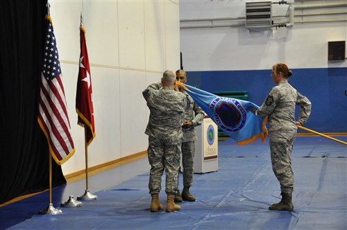 STUTTGART, Germany - General Carter Ham, commander of U.S. Africa Command (facing back), and Chief Master Sergeant Jack Johnson Jr., U.S. Africa Command's senior enlisted leader, attach a Joint Meritorious Unit Award streamer onto the command's flag during an all-hands meeting, March 9, 2012. The award recognizes the command staff for their response to the conflict in Libya between March 19 and March 30, 2011. During this time, the command coordinated humanitarian and military operations to maintain stability in the region, established a no-fly zone over Libya, and enforced an arms embargo at sea. (U.S. AFRICOM photo by Danielle Skinner)