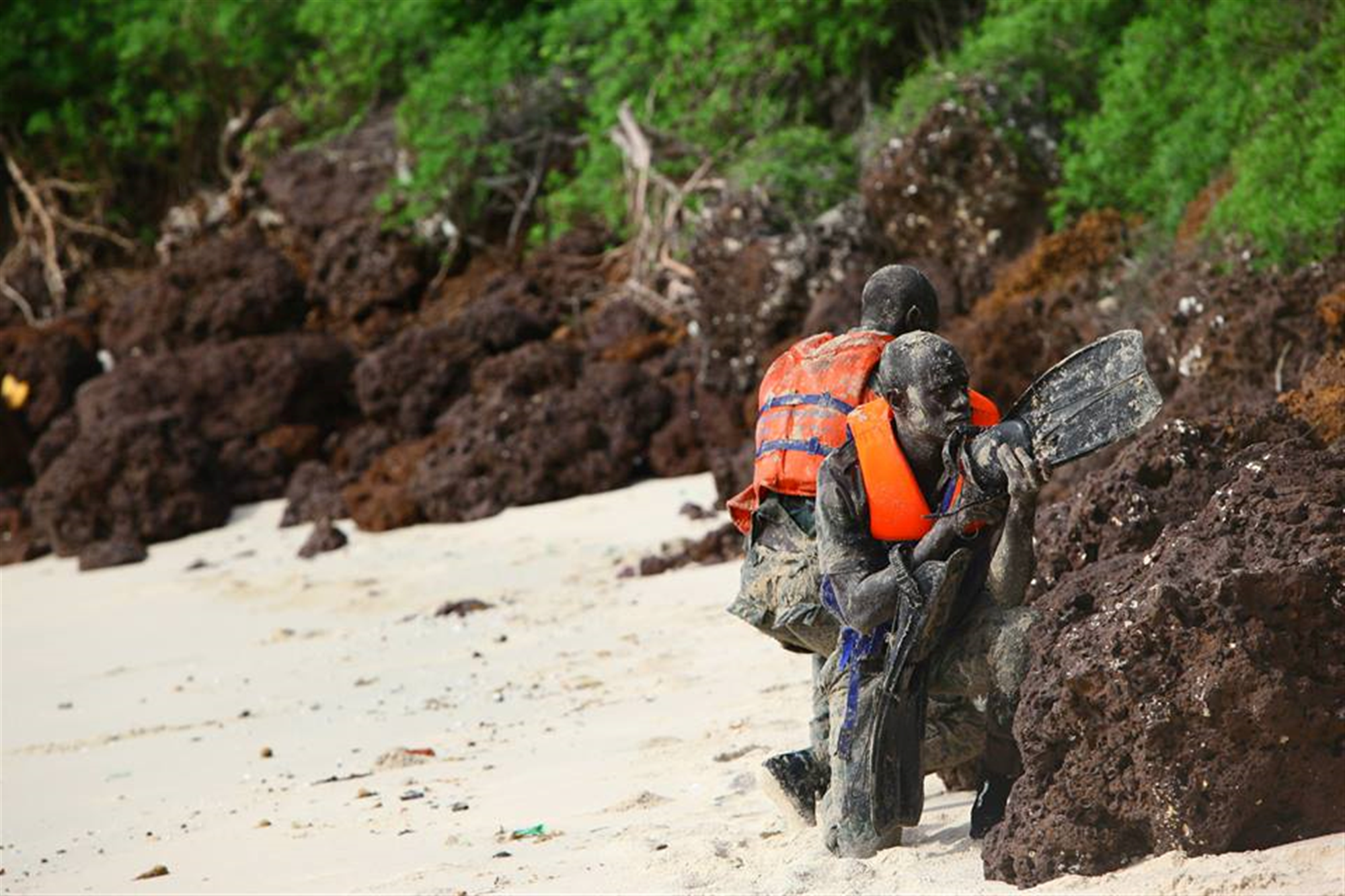 Senegalese Companie de Fusilier Marine Commandos post security after swimming ashore ahead of their team ensuring the beach is clear of enemies or obstacles prior to the team insertion on Bel Air Naval Base in Dakar, Senegal, after being taught by Marines and sailors with Special-Purpose Marine Air-Ground Task Force Africa 13, Aug. 16, 2013. Special-Purpose MAGTF Africa strengthens U.S. Marine Corps Forces Africa and U.S. Africa Commands ability to assist partner nations in theater security cooperation and military-to-military engagements. Special-Purpose MAGTF Africa’s current iteration is the fourth rotation working with the Senegalese Forces. (U.S. Marine Corps photo by Cpl. Ryan Joyner/Released)