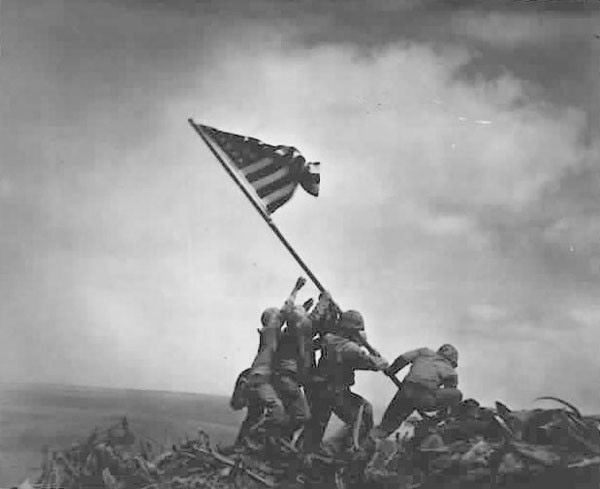 Five U.S. Marines and a Navy corpsman raise a flag on top of Mount Suribachi, Feb. 23, 1945. The iconic photograph, taken by AP photographer Joe Rosenthal and recreated in the U.S. Marine Corps War Memorial, captured the second U.S. flag-raising atop the mountain that day. Photo courtesy of National Archives and Records Administration