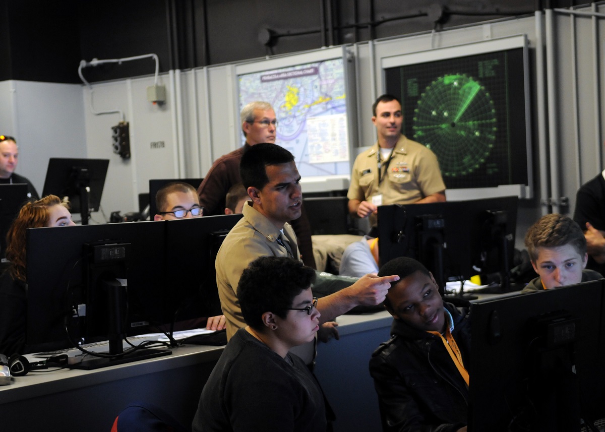 PENSACOLA, Fla. (Jan. 23, 2016) Cryptologic Technician (Networks) Seaman Anthony Chavez, an information warfare student from the Center for Information Dominance Unit Corry Station, mentors high school students during CyberThon, an event designed to develop the future cybersecurity workforce.  Hosted by the Blue Angels Chapter of the Armed Forces Communications and Electronics Association, CyberThon challenged the students to play the role of newly hired information technology professionals tasked with defending their company's network. U.S. Navy photo by Carla M. McCarthy 