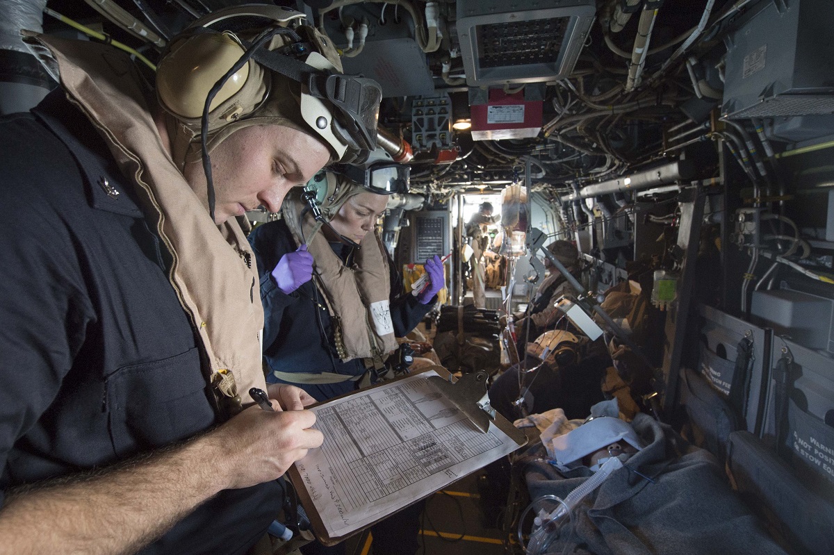 ARABIAN GULF (Dec. 31, 2015) Hospital Corpsman 2nd Class Tracey Farris (left), from Arvin, California, and intensive care corpsman embarked aboard USS Kearsarge attached to Fleet Surgical Team (FST) 4, records a patient's vital signs during a medical evacuation drill in an MV-22 Osprey. Kearsarge is the flagship for the Kearsarge Amphibious Ready Group (ARG) and, with the embarked 26th Marine Expeditionary Unit (MEU), is deployed in support of maritime security operations and theater security cooperation efforts in the U.S. 5th Fleet area of operations.  U.S. Navy photo by Mass Communication Specialist 3rd Class Tyler Preston 