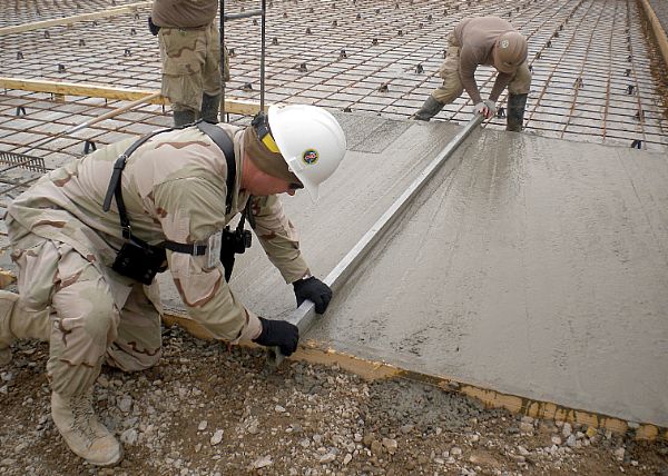 KANDAHAR PROVINCE, Afghanistan (Feb. 4, 2012) Senior Chief Builder Robert Morrison, left, and Builder 3rd Class Nathaniel Callaham, assigned to Detachment PASAB of Naval Mobile Construction Battalion (NMCB) 7, level concrete with a metal screed during the placement of concrete pads at Forward Operating Base PASAB. NMCB-7 and its detachments are one of two Seabee battalions supporting the International Security Assistance Force as part of Task Force Stethem in the U.S. Central Command area of responsibility. The identification card in this photo has been altered for security reasons. U.S. Navy photo by Ensign Daniel Cloutier.