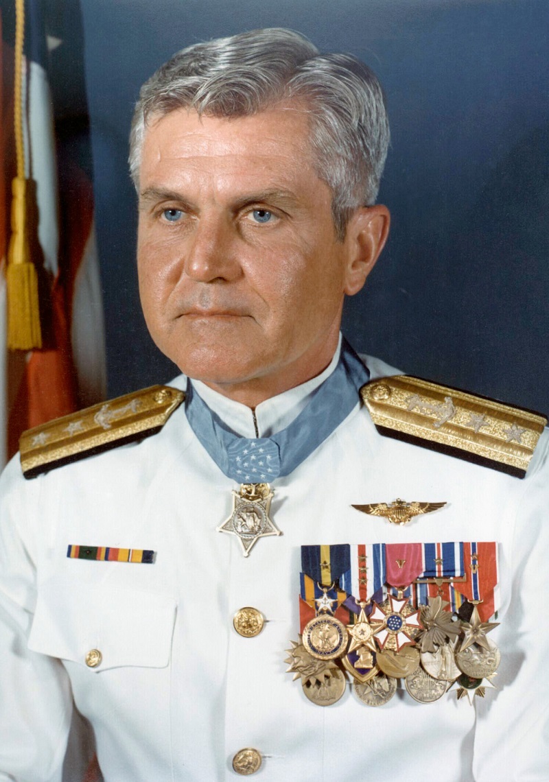 Formal portrait of Rear Adm. James B. Stockdale in full dress white uniform. He is one of the most highly decorated officers in the history of the Navy, wearing 26 personal combat decorations, including two Distinguished Flying Crosses, three Distinguished Service Medals, two Purple Hearts, and four Silver Star medals in addition to the Medal of Honor. Later he obtained the rank of Vice Admiral, and is the only three-star Admiral in the history of the Navy to wear both aviator wings and the Medal of Honor. U.S. Navy photo  