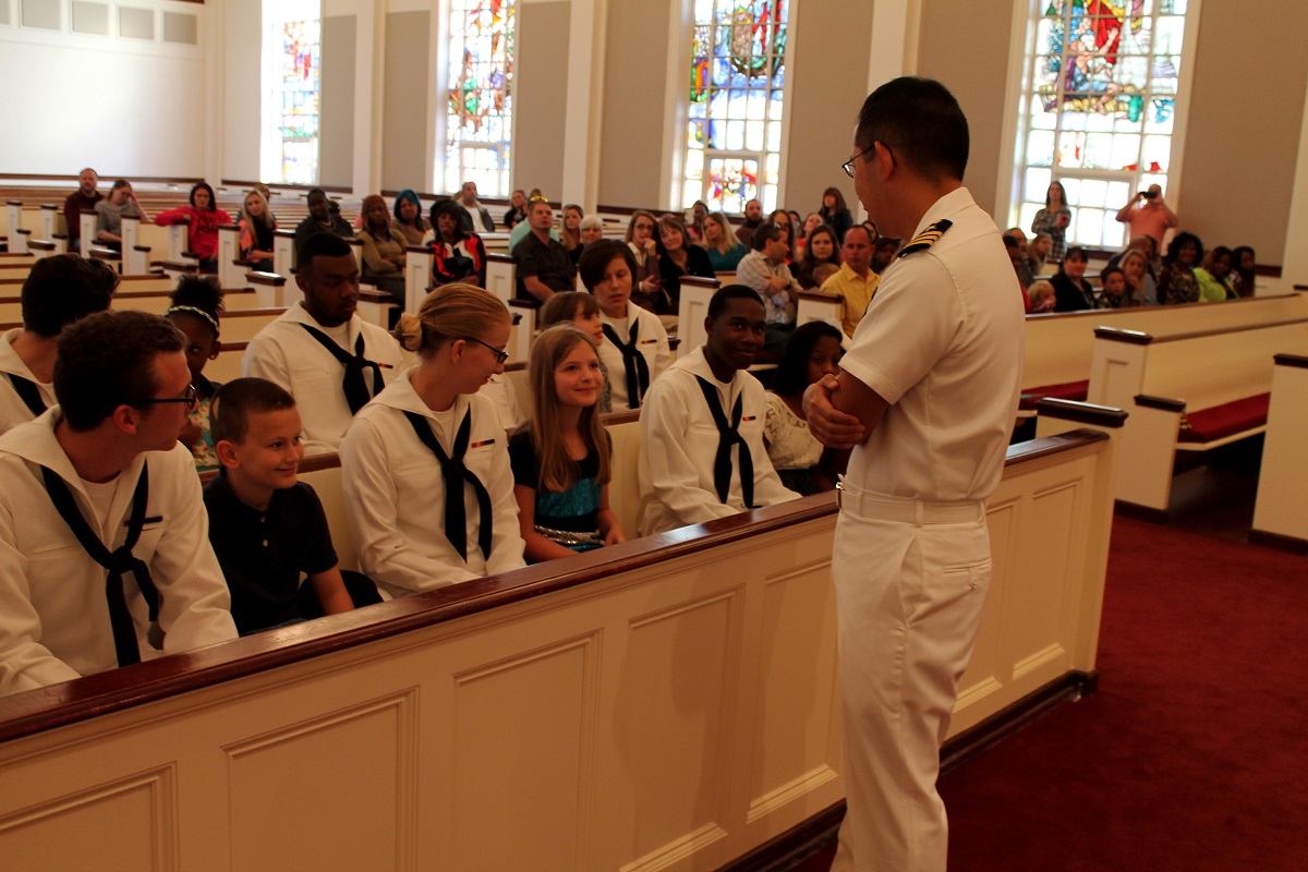 Cmdr. Christopher Eng, commanding officer for Center for Information Dominance Unit Corry Station, talks with Jim Allen Elementary School students and their mentors, during a Saturday Scholars Program graduation at Naval Air Station Pensacola Chapel, Nov. 21. U.S. Navy photo by IT2 Nathan Hays