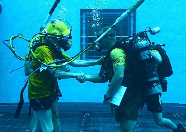 PANAMA CITY, Fla. (May 27, 2015) Secretary of the Navy (SECNAV) Ray Mabus presents an award to Gunnery Sgt. Bo Irving, a Marine Corps combatant diver course instructor, in the aquatic training facility at Naval Diving and Salvage Training Center. NDSTC is the largest diving training facility in the world and is home of the military diver. U.S. Navy photo by Mass Communication Specialist Fred Gray IV.