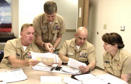 Vice Adm. Jan E. Tighe, commander, Fleet Cyber Command and commander, U.S. 10th Fleet, right, discusses educational requirements for cyber and the course matrices that support those requirements with, from left, Capt. James Mills, Lt. Cmdr. Eric McMullen, and Capt. Doug Powers during a visit to the university campus in Monterey, Calif. Tighe visited the institution for a biennial curriculum review to ensure the programs continue to deliver graduates that meet the evolving operational needs of the Department of Navy and other services. Photo by Javier Chagoya/NPS.