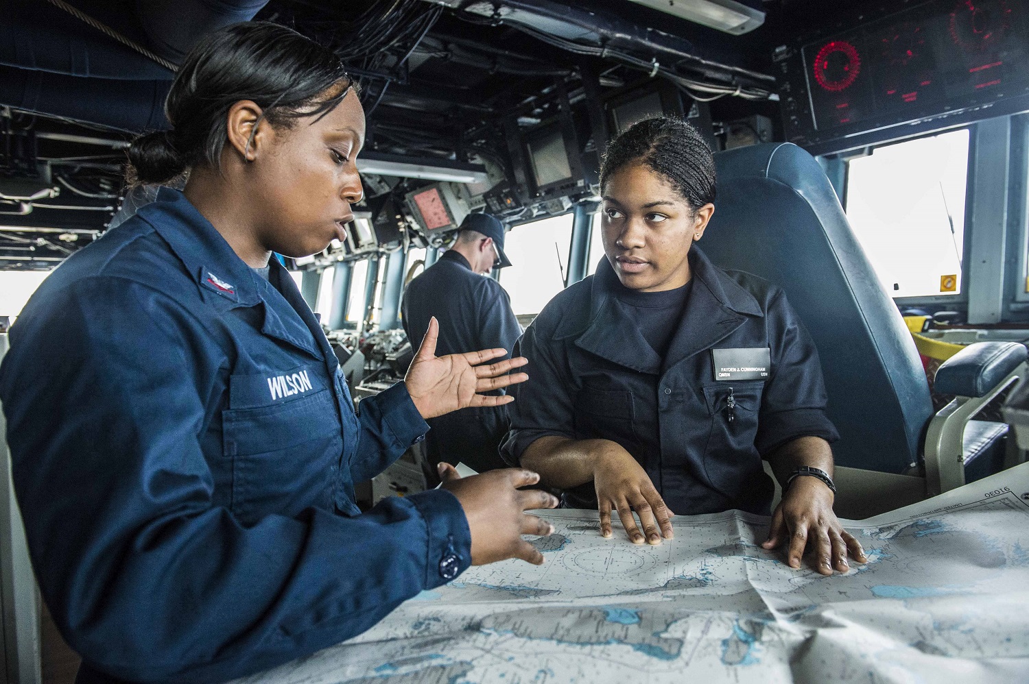 SOUTH CHINA SEA (April 20, 2015) Quartermaster 2nd Class Nyzherelle Wilson, left, from Orangeburg, S.C., conducts training with Quartermaster Seaman Fayden Cunningham, from Bloomfield, N.J., on the bridge of the Arleigh Burke-class guided-missile destroyer USS Mustin (DDG 89). Mustin is on patrol in the U.S. 7th Fleet area of responsibility in support of security and stability in the Indo-Asia-Pacific region. U.S. Navy photo by Mass Communication Specialist Seaman David Flewellyn.